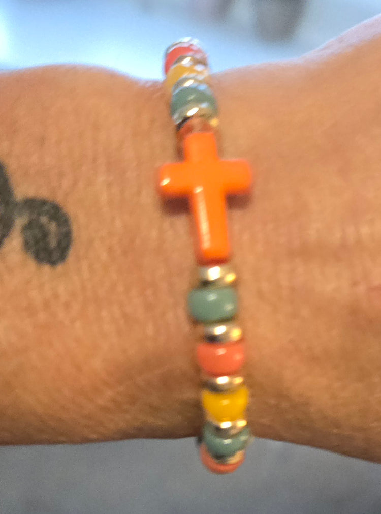 Green, yellow and orange beaded bracelet with orange cross charm