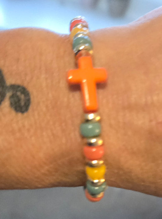 Green, yellow and orange beaded bracelet with orange cross charm