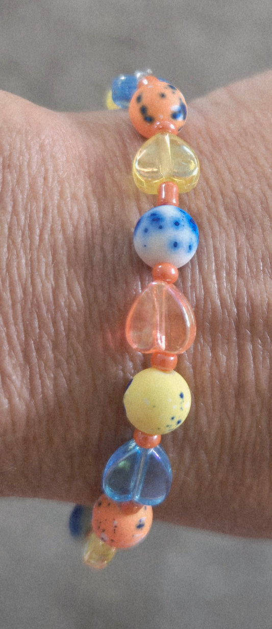 Tie dyed orange, blue and yellow heart beaded bracelet