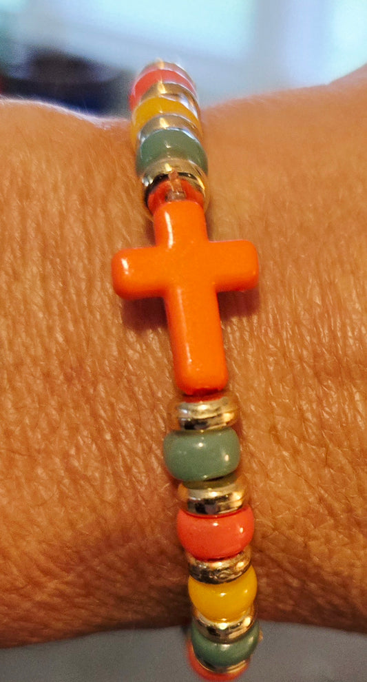 Green, yellow and orange beaded bracelet with orange cross charm